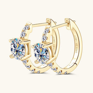 Gold hoop earrings with clear gemstones on a white background
