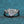 Silver ring with a large diamond and smaller diamonds on a blue textured background