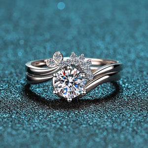Silver ring with a large diamond and smaller diamonds on a blue textured background