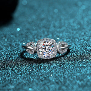 Diamond ring and earrings on a glittery blue surface