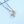 Silver necklace with a cube pendant on a light blue background