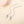 Silver necklace with square pendant on a beige background