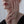 Close-up of a person's hand touching their face with a neutral background