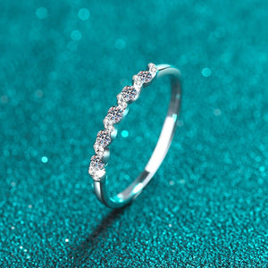 Silver ring with small diamonds on a teal glittery background