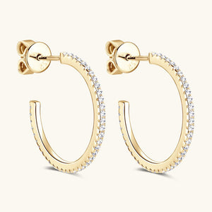 Gold hoop earrings with clear gemstones on a white background
