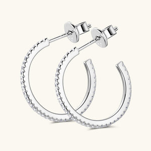 A pair of gold-colored hoop earrings with moissanite pave settings.
