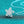 Silver butterfly pendant necklace on a turquoise glittery background