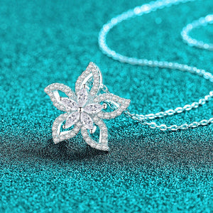 Silver butterfly pendant necklace on a turquoise glittery background