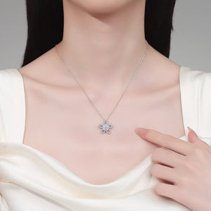 Necklace with a star-shaped pendant worn by a person in a white outfit.