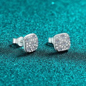 Pair of silver earrings with gemstones on a teal glittery background