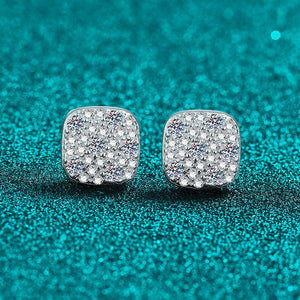 Silver glittery square earrings on a teal glitter background