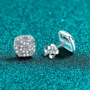 Silver earrings with gemstones on a teal glittery background