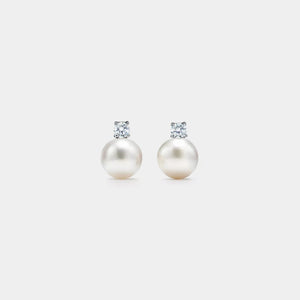 Pair of pearl earrings with small diamonds on a white background