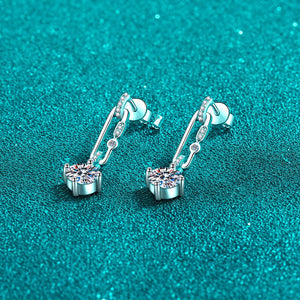 Silver earrings with gemstones on a teal glittery background
