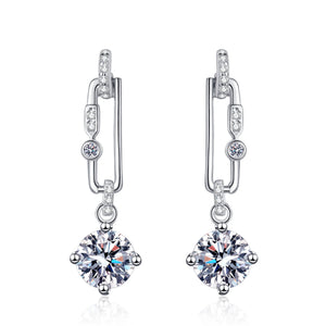 Pair of silver earrings with clear gemstones on a white background