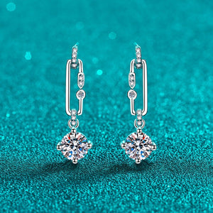 Silver earrings with gemstones on a teal glitter background