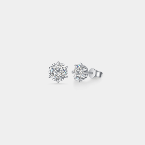 A pair of sterling silver stud earrings with snowflake designs, featuring certified Moissanite stones.
