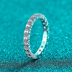 Silver ring with diamonds on a teal background