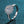 Silver ring with a large central diamond and smaller diamonds on a blue glittery background