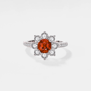 A moissanite gemstone set in a flower-shaped ring with a hypoallergenic platinum finish.