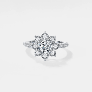 A moissanite gemstone set in a flower-shaped ring with a hypoallergenic platinum finish.