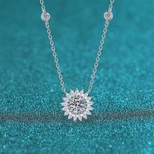 Silver necklace with a diamond pendant on a teal glittery background