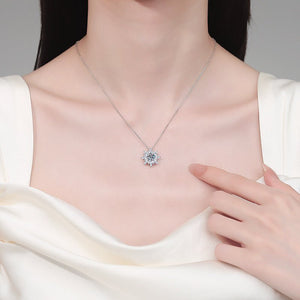 Necklace with a diamond pendant worn by a model, with a hand touching the necklace.
