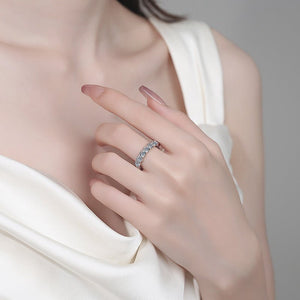 Close-up of a hand wearing a silver ring with a blurred background
