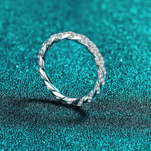 Silver ring with diamond accents on a teal textured background