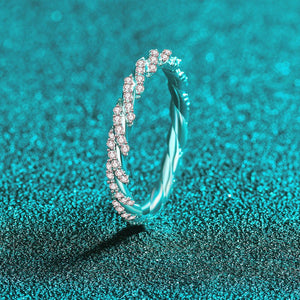 Silver ring with pink gemstones on a teal glittery background