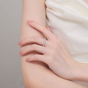 Close-up of a hand wearing a silver ring on a neutral background