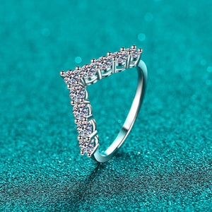 Silver ring with diamond accents on a teal background