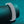 Silver bracelet on a teal cylindrical object with a teal background