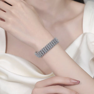 Silver bracelet on a person's wrist with a white background