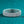 Silver bracelet with intricate design on a teal background