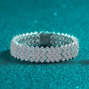 Silver bracelet with intricate design on a teal background