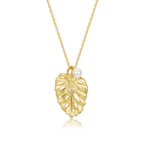 Gold leaf pendant necklace with a pearl on a white background
