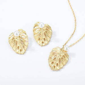 Gold leaf earrings and necklace set on a white background