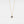 Gold necklace with a blue gemstone pendant on a light gray background