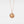 Rose gold necklace with a round locket featuring a moon face and star on a light gray background