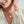 A woman wearing a gold photo locket necklace featuring a moon phase design with a star in the center.