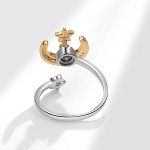 Gold and silver spinner ring with moon and star design on a white background