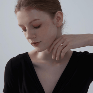 Model wearing a gold spinner ring with star and moon design on a white background