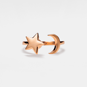 Rose gold star and moon spinner ring on a light gray background