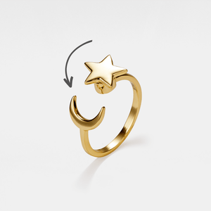 Gold star and moon spinner ring on a light gray background