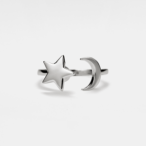 Silver star and moon spinner ring on a light gray background