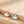 Two necklaces with round pendants featuring cartoon characters on a beige surface.
