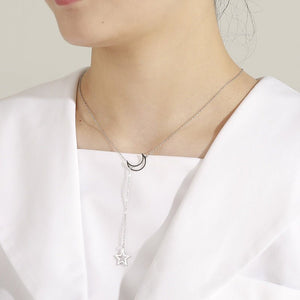 Star-shaped necklace worn by a person on a plain background
