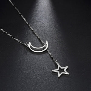 Silver necklace with a crescent moon and star pendant on a dark background