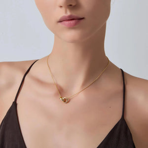 Gold necklace on a model against a neutral background